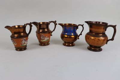four different sized vases are lined up on a white surface