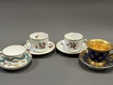 trois tasses et soucoupes sont posées sur une surface grise