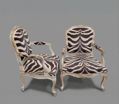 pair of zebra print chairs on a grey background