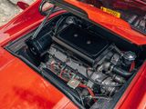 a small engine in the engine bay of a red sports car