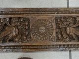 carvings on the wall of a bathroom with a toilet in the background
