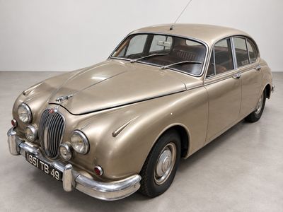 une photo d'une voiture de couleur beige garée dans une pièce