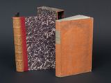 deux vieux livres posés l'un à côté de l'autre sur une surface noire