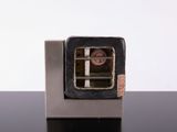 une petite boîte métallique munie d'une fenêtre, posée sur une table