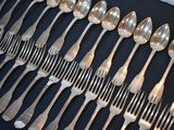 a lot of silver spoons and forks on a table