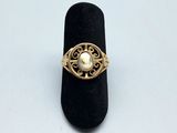 une image représentant une bague en or ornée d'une perle au centre
