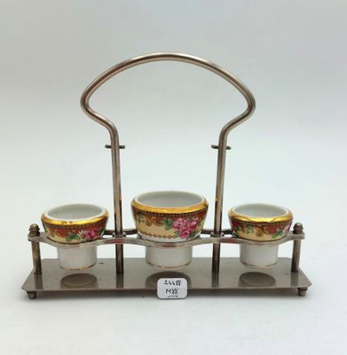 trois tasses dans un support en métal muni d'une poignée