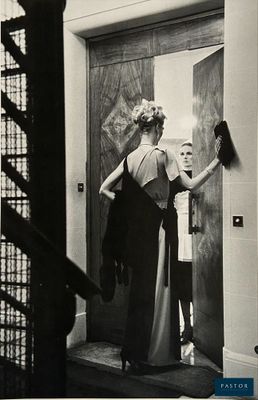black and white photograph of a woman standing in front of a door