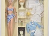 une poupée Barbie dans une vitrine, avec des vêtements et des accessoires