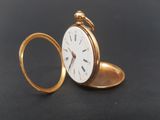 a gold pocket watch sitting on a black surface