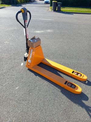 un chariot élévateur jaune garé au milieu d'un parking, à côté d'un parcmètre