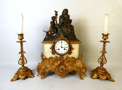 trois bougies et une horloge posées sur une table