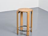 a wooden stool with a metal ring on it