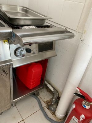 une cuisine équipée d'une cuisinière, d'un évier et d'un extincteur