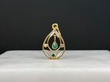 un gros plan sur un pendentif en or orné d'une larme verte