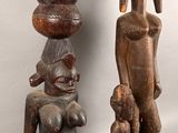 two wooden sculptures of a woman and a child on a table