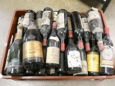 plusieurs bouteilles de vin dans une caisse en bois posée par terre