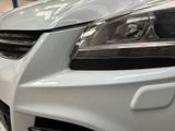 the front end of a white car with the hood down
