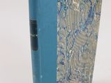 un livre à la couverture bleue posé sur une surface blanche