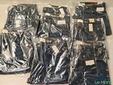 several pairs of jeans are wrapped in plastic bags on a table
