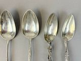 four spoons are lined up in a row on a table