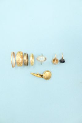 many different types of rings and earrings laid out on a blue surface