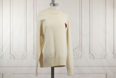le pull, orné d'un cœur, est présenté sur un mannequin
