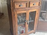 une armoire en bois avec une porte vitrée et une cage à oiseaux