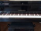 a piano in the corner of a room with a painting on the wall behind it