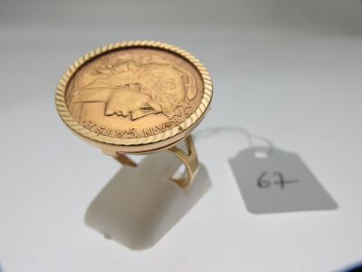 une bague en or ornée d'une pièce de monnaie et d'une étiquette de prix