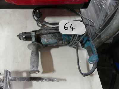 une photo d'une perceuse filaire et d'un marteau posés sur une table