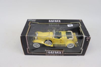 un camion jouet jaune dans une boîte, posé sur une surface blanche