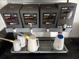 three jugs of water and two jugs of liquid on a shelf