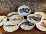 many plates with different types of fish on them on a table