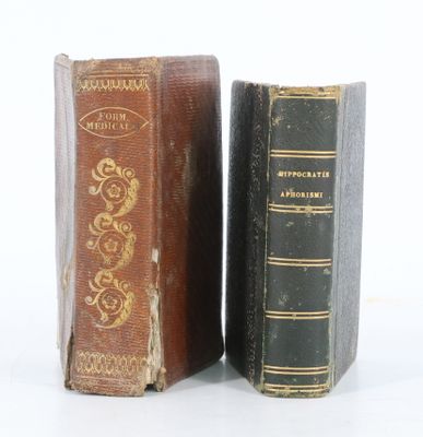 deux vieux livres posés l'un à côté de l'autre sur une surface blanche