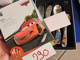 une personne tenant une boîte d'argenterie sur laquelle figure une image de voitures