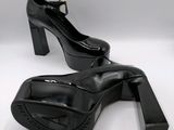 black high heeled shoes on a white surface with a white background