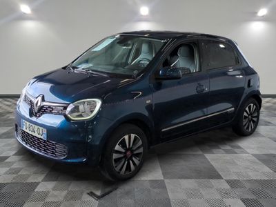 une voiture bleue est garée dans une pièce au sol à carreaux