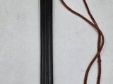a close up of a knife on a white surface with a red cord