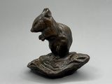 figurine en bronze représentant un écureuil assis sur une feuille