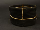 an old black hat with a gold stripe on it