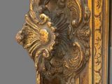 a large mirror with a gold frame and a bird on it