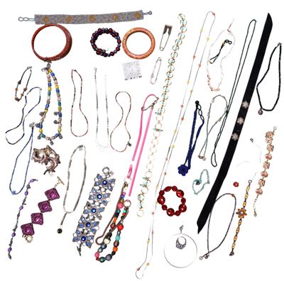 many necklaces and bracelets laid out on a white surface