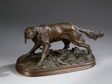 statue représentant un chien en train de courir, posée sur un socle en bois, sur une surface blanche