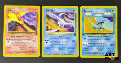 trois cartes Pokémon posées sur une table avec un fond noir
