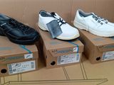 Plusieurs paires de chaussures sont posées sur des cartons, sur une table.