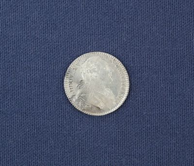 un gros plan d'une pièce d'argent posée sur un tissu bleu