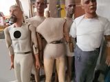 plusieurs mannequins dans un atelier, avec un homme debout à côté d'eux
