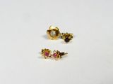 two small gold earrings with pink and white stones on a white surface