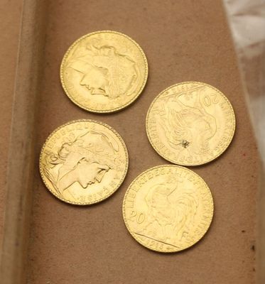quatre pièces d'or posées dans une boîte en carton sur une table